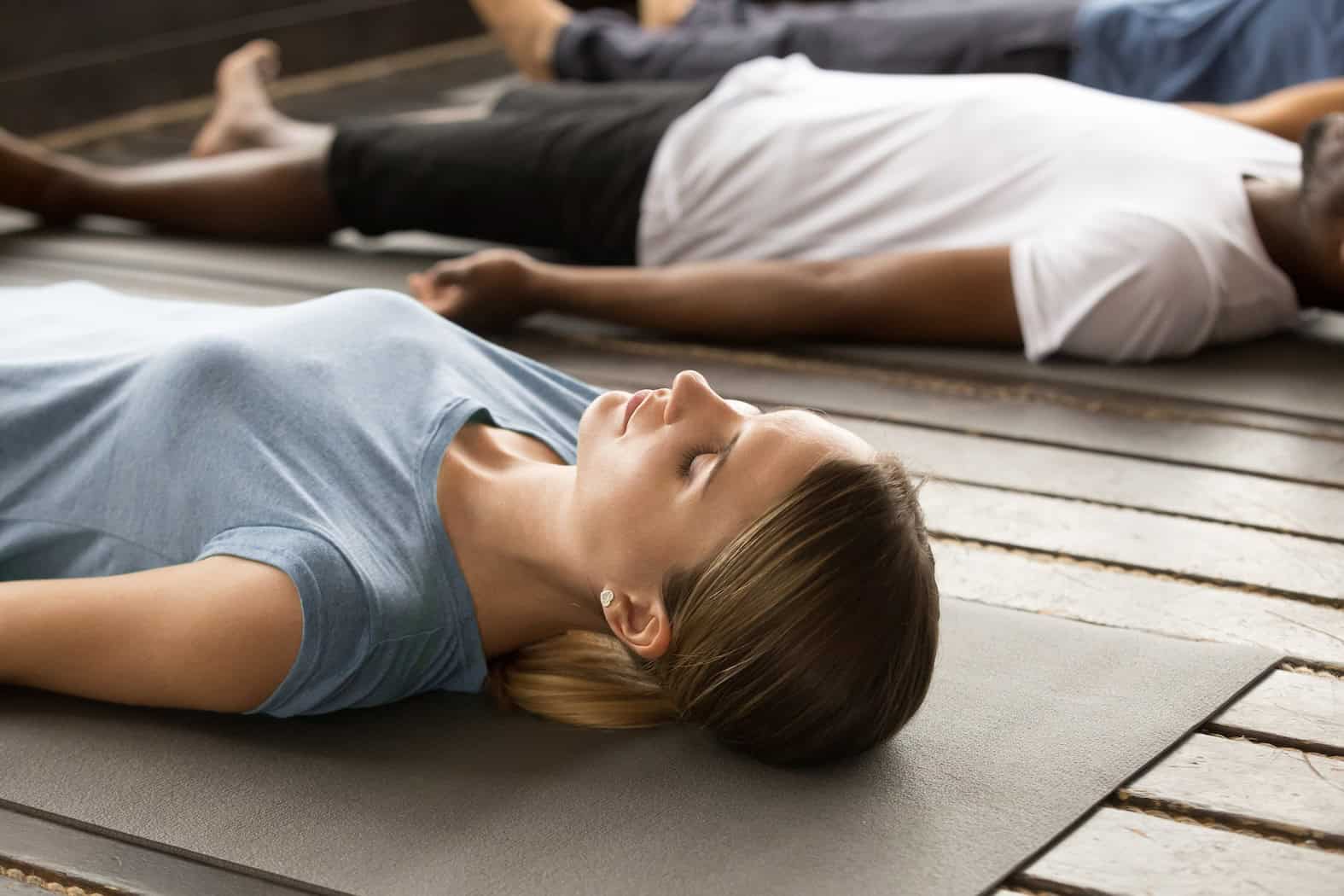 Personnes en séance de sophrologie, allongées et pratiquant des exercices de relaxation