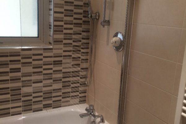 Tiled bathroom tub with shower screen