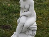 Marmorfigur- siddende pige på sten