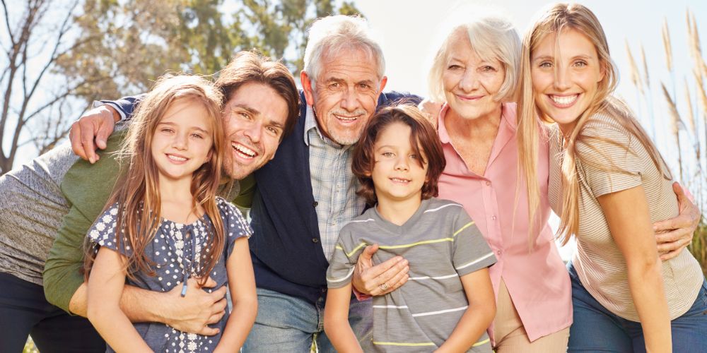 Sandwich generation parents with their children and grandparents posing for a photo