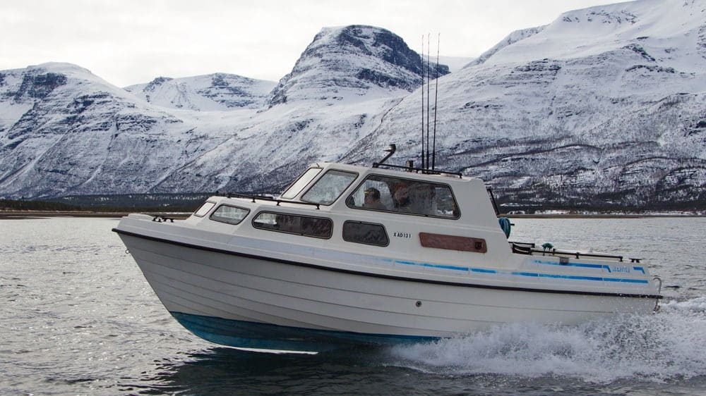 Boat rental on the fjord near Skibotn with snow-capped Lyngen Alps in the background, Northern Norway