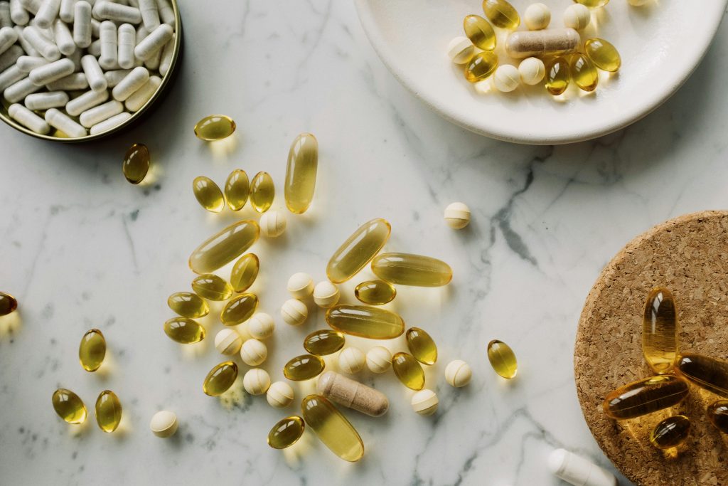 pexels-photo-3850790-3850790 A collection of supplements and pills scattered on a marble surface, showcasing healthcare essentials.