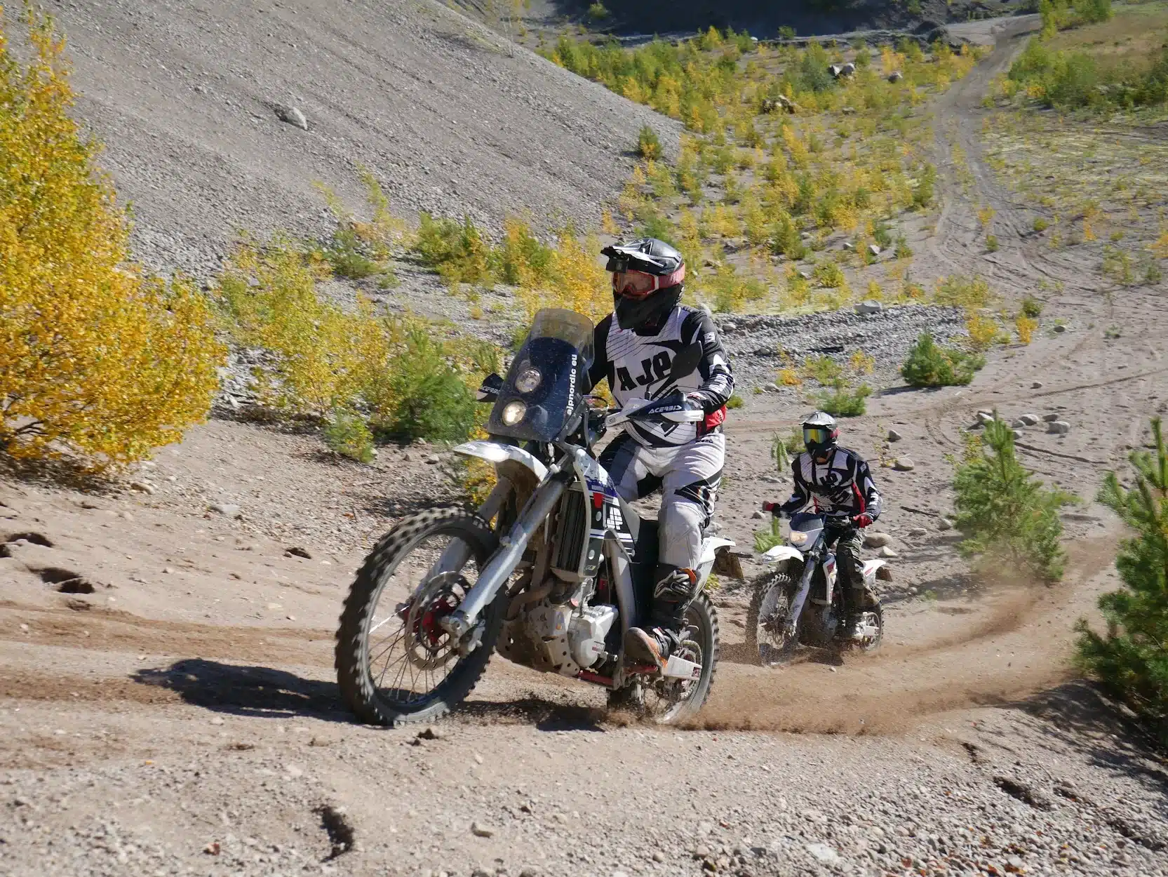 Two AJP motorcycles on a sand hill