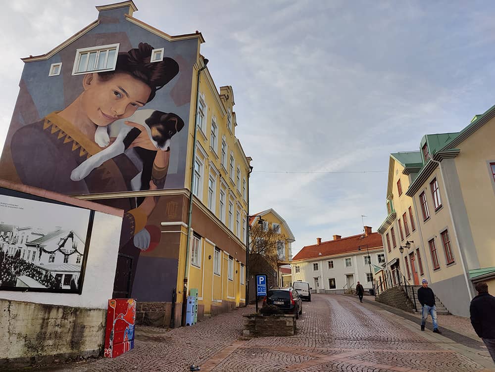 Een grote muurschildering op een gebouw in een straat van Oskarshamn.