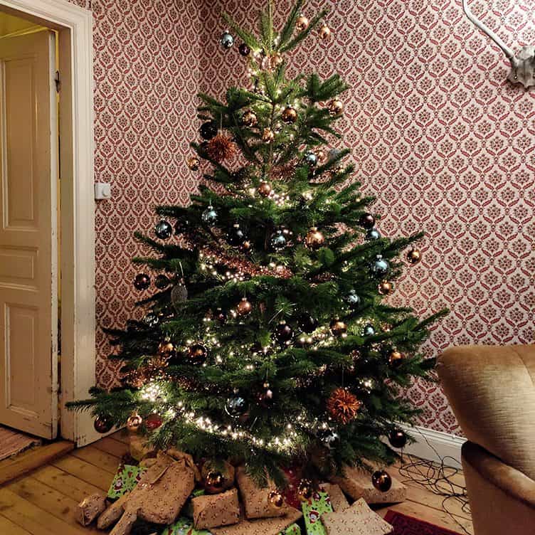 Een kerstboom met cadeautjes in een Zweedse woning.