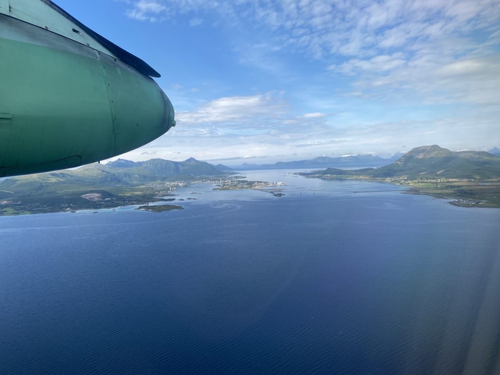 Reiseforsikring er bra på flyreiser, widerøefly i lufta over en øy.