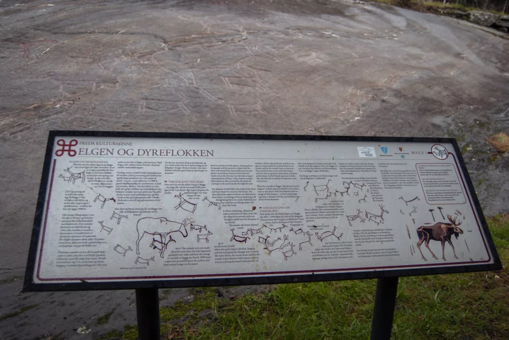 Photograph of the petroglyphs at Bogge and an information sign about the petroglyphs.