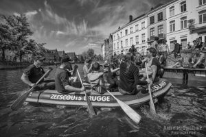 Black and white photo of the Sea Scouts and rubber boat on the canals in Brugge during the opening ceremony of the Triënnale, 2015