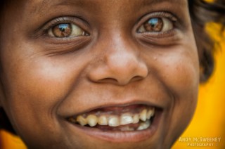 Close-up portrait of a beggar child giving the big eyes and big smile for the camera in South-India