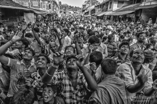 Black and white portrait of an Indian crowd catching and throwing bananas during Shivaratri festival in Gokarna, South-India