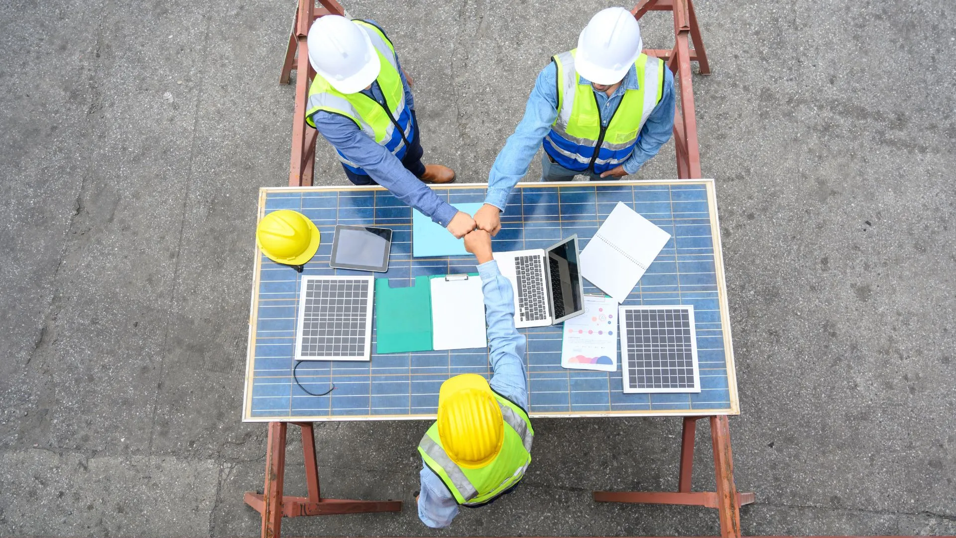 Trois personnes travaillent ensemble sur un chantier. 