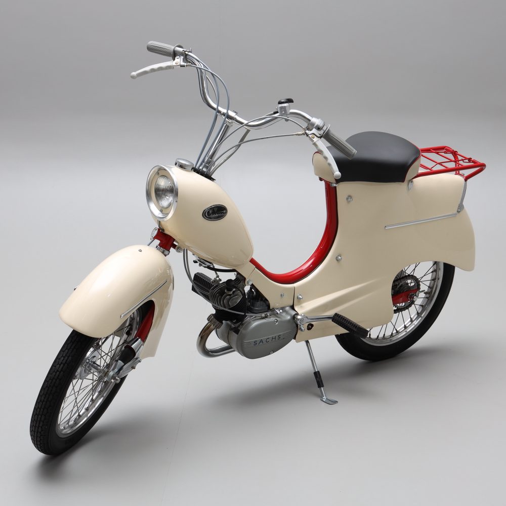 Crescent moped 1950-tal. Lackerad gräddvit med röda detaljer. Svart läderklädsel på sitsen.