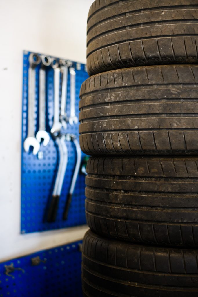 stablede dæk som er klar til at blive sat på - Værkstøj vises i baggrunden hængende på blå væg
