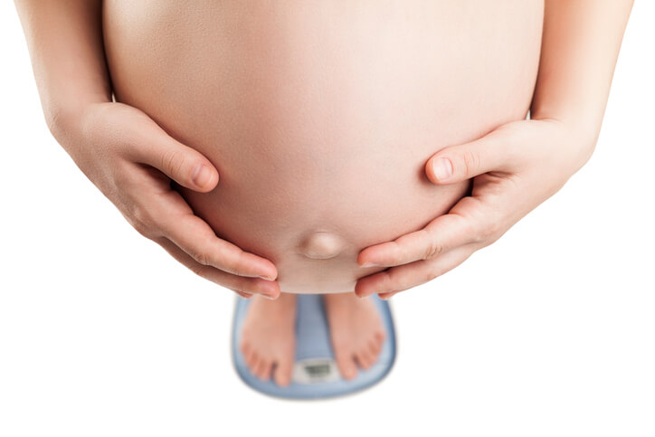 Vægtøgning i graviditeten, hvormeget? Højgravid kvinde står på en vægt