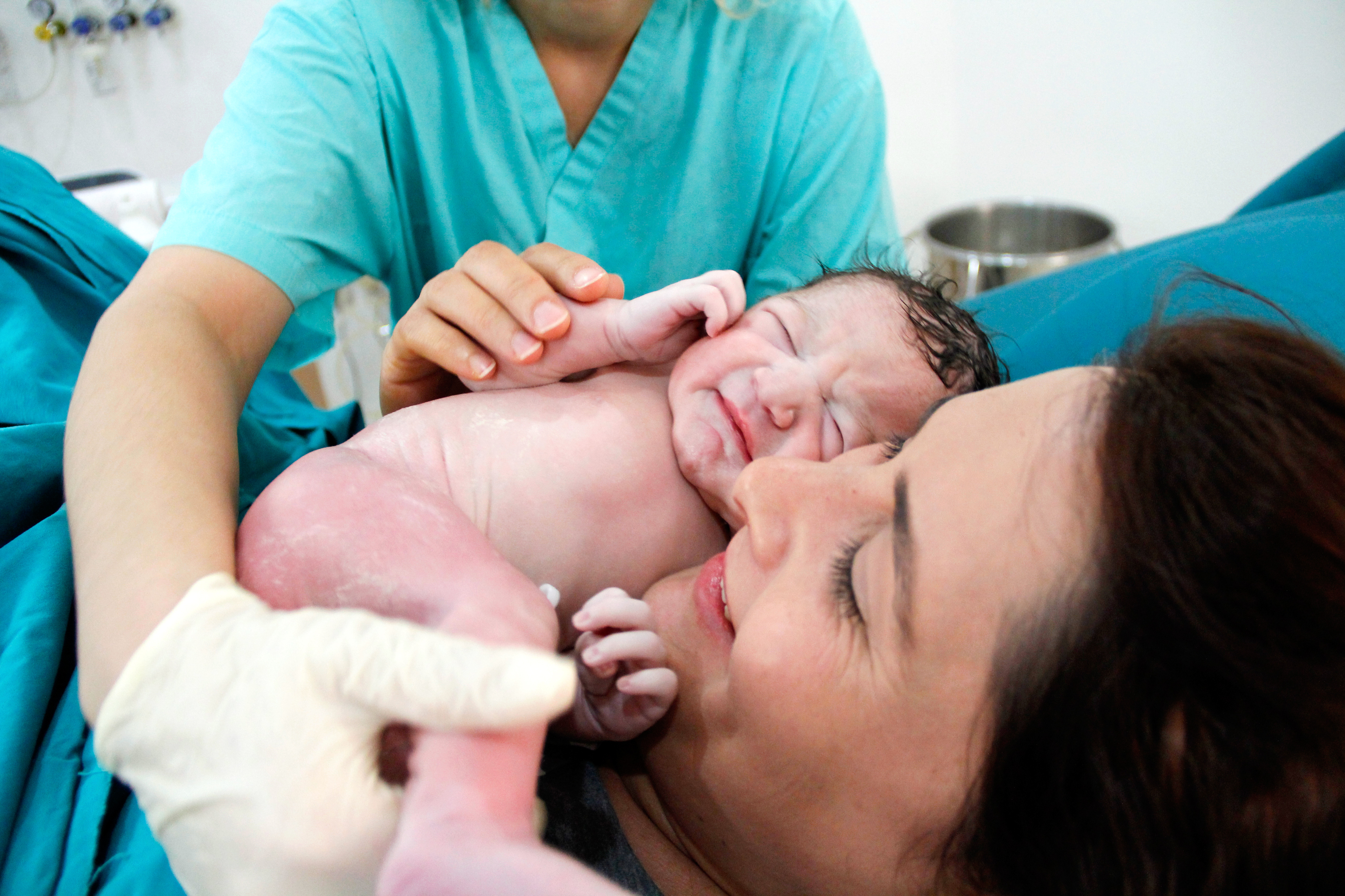 Nyfødt baby ligger på mors mave lige efter fødslen