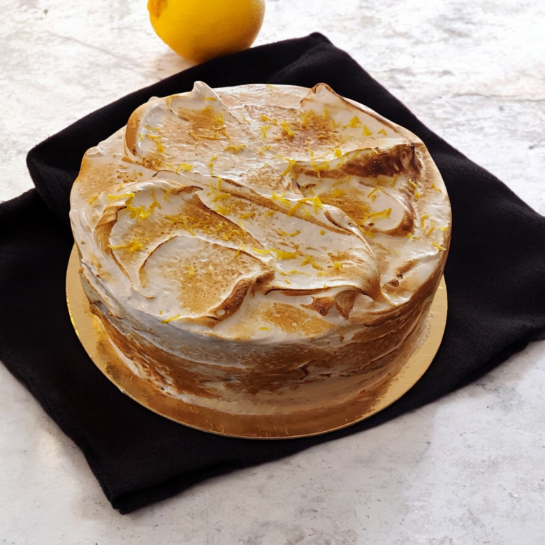 På bilden är det en tårta som består av tårtbottnar varvat med citronkrämgrädde och täck med bränd italiensk maräng. Den representerar våran produkt cipriani tårta,