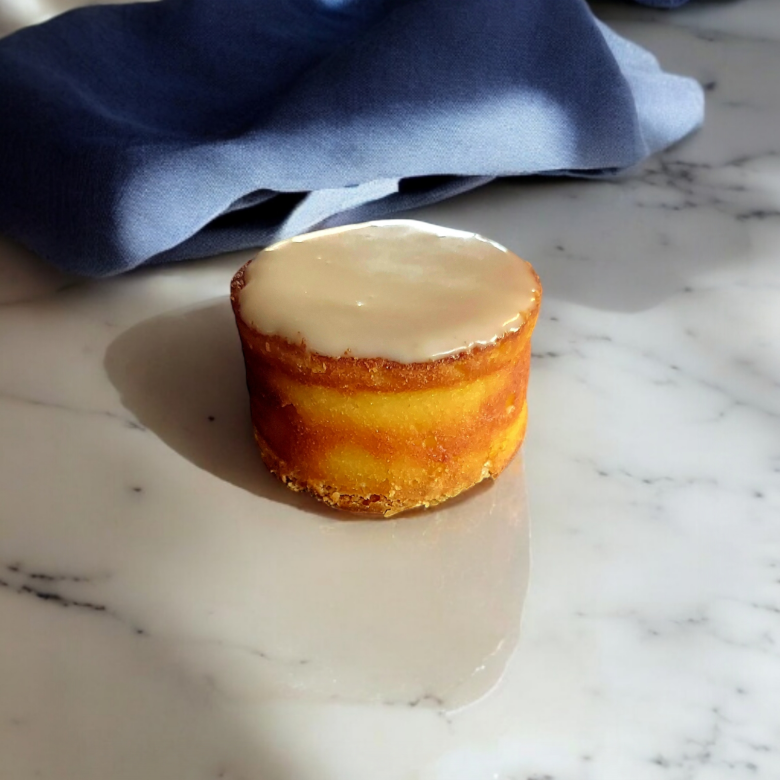 På bilden är det en mazarin. Den är bakad i en rund form och har en glasyr av florsocker uppepå. Den representerar våran produkt mazarin.