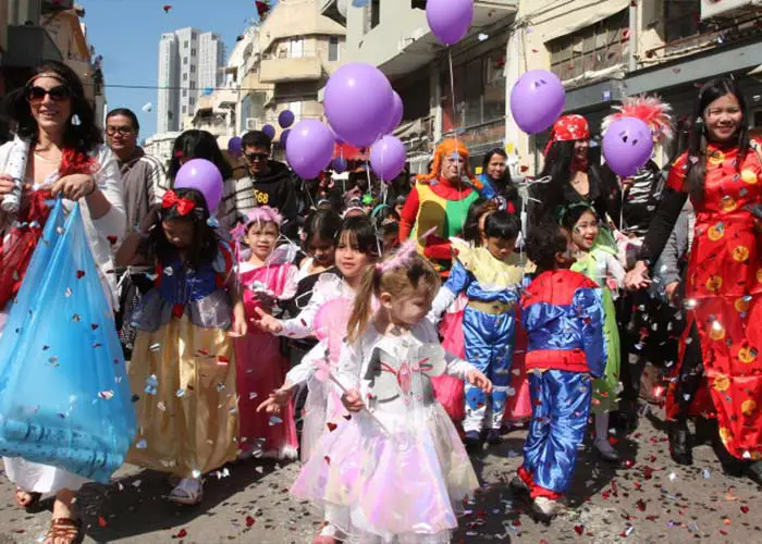 Children and adults take to the streets in costume during Purim in Israel