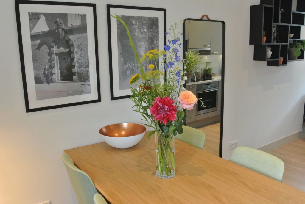 Klein boeket met bloemen op de eettafel in hotelkamer.