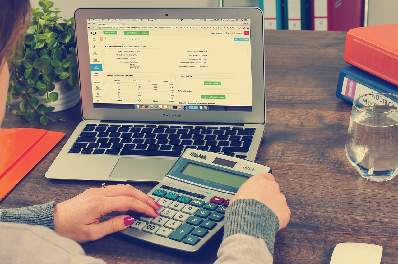 a person using a calculator and a laptop