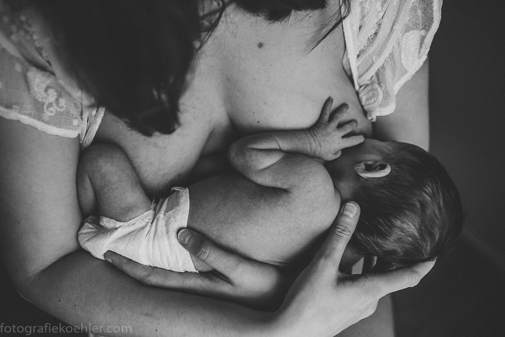 auf dem Bild ist eine stillende Mutter mit ihrem Baby an der Brust zu sehen