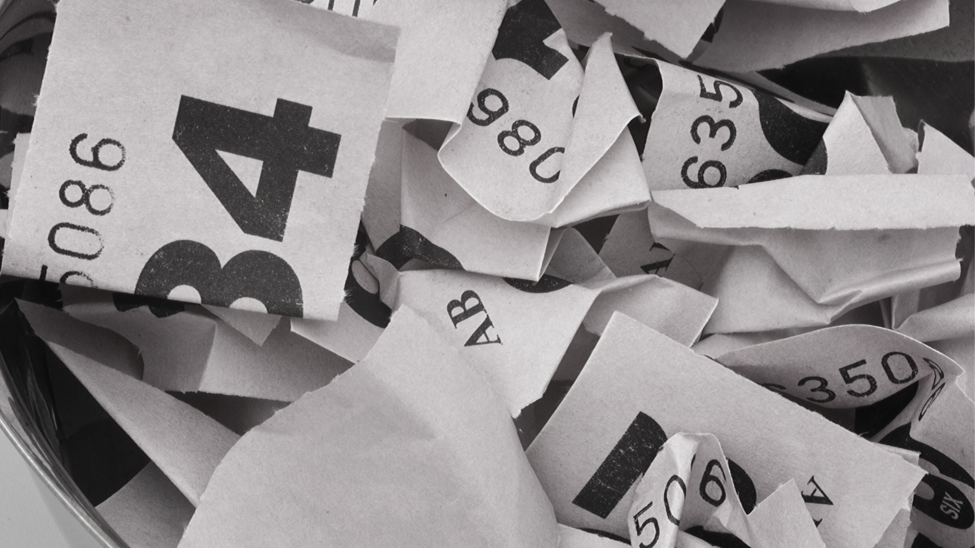 Close-up black and white photo of crinkled queuing tickets