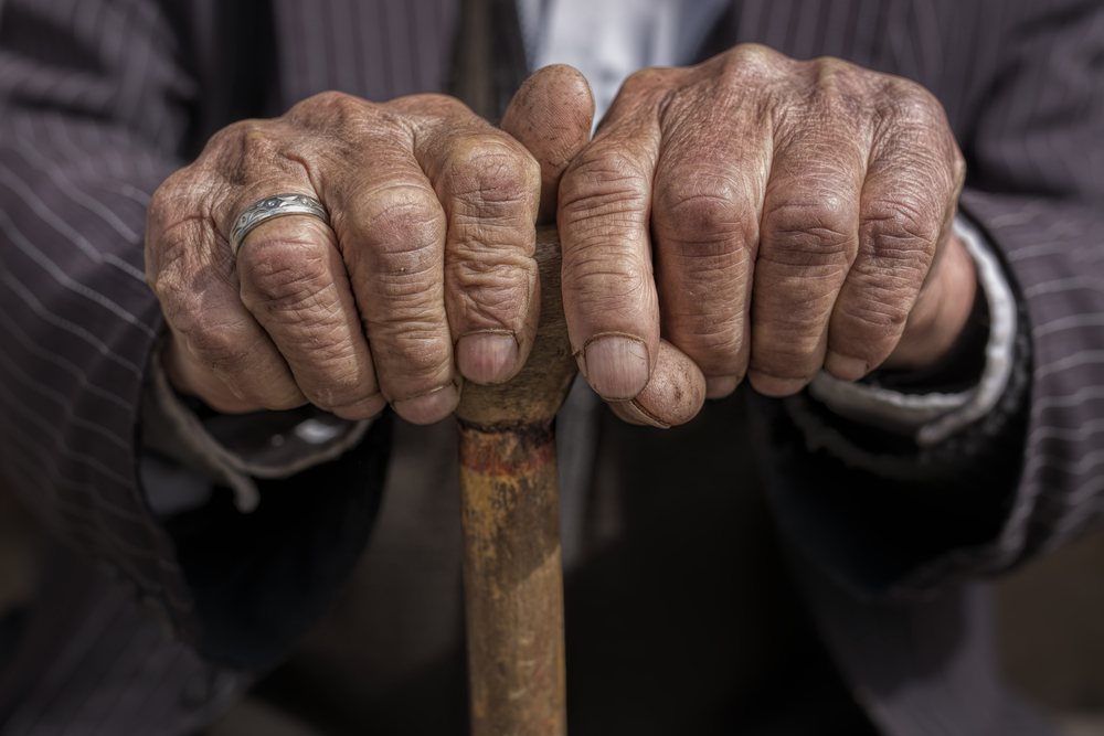 hands of old man holding a cane