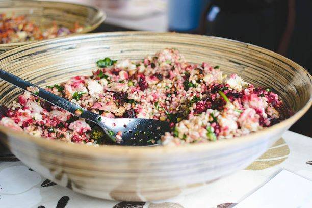 Hälsosam sallad med grönsaker och legymer i en stor skål med salladsbestick liggandes i, prebiotika för tarmbakterierna 