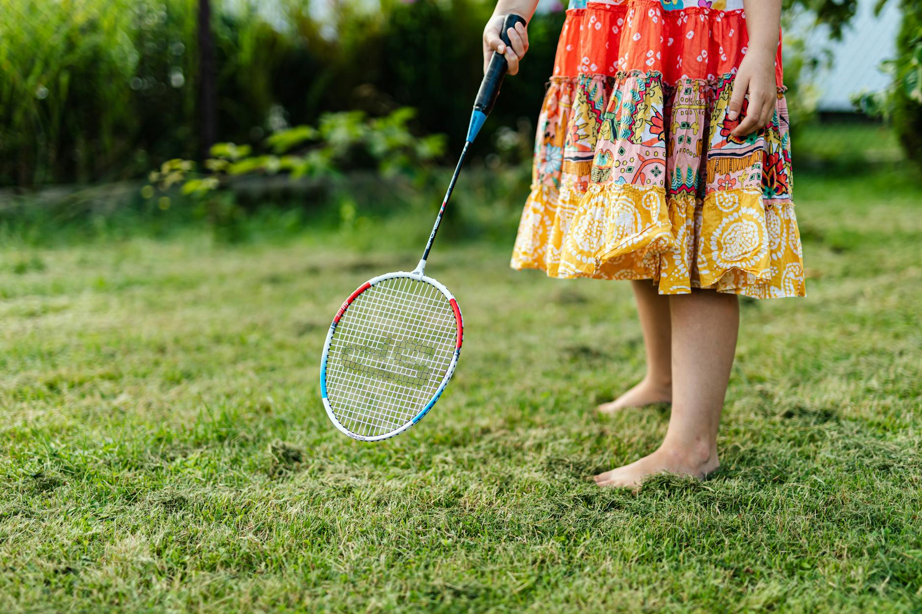 a person in floral dress holding a badminton racket