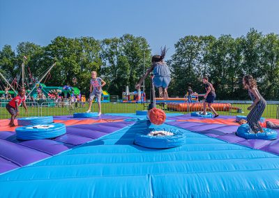 Springen op sweeper met attracties in achtergrond op schoolpein