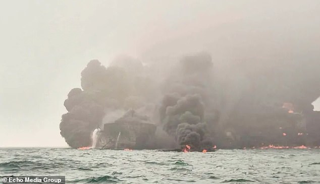 Smoke can be seen billowing from the sea as oil carried on the carrier caught fire