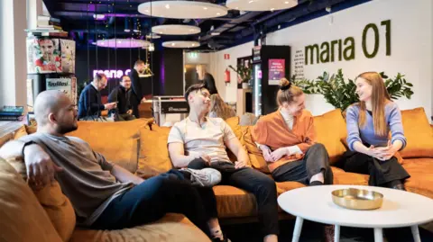 Maria 01 Four young entrepreneurs sit on an orange sofa at Maria 01 in Helsinki