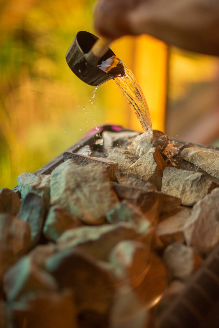 Vand hældes på stenene i sauna