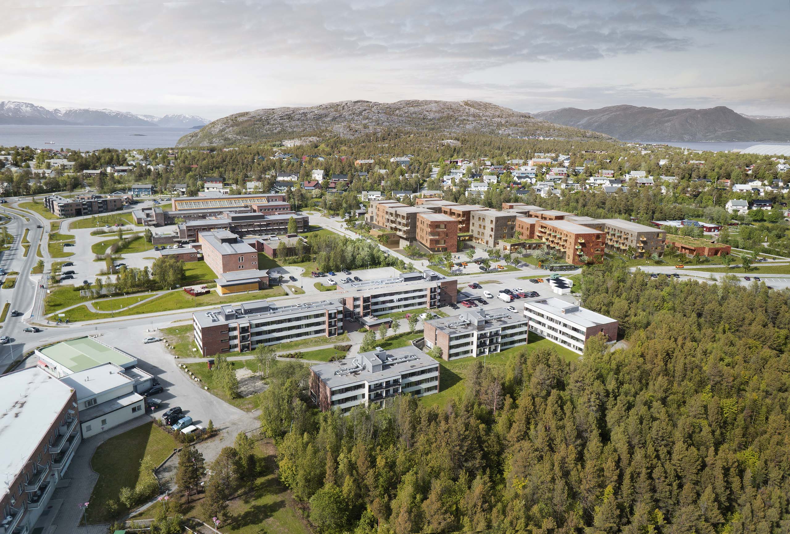 <strong>Alta Omsorgssenter</strong> – Competition Winner Aerial view of Alta Omsorgssenter in Norway, designed by Asas Arkitektur, showcasing a modern care center complex with multiple red-brick buildings integrated into a green suburban landscape, surrounded by residential areas and mountain scenery.