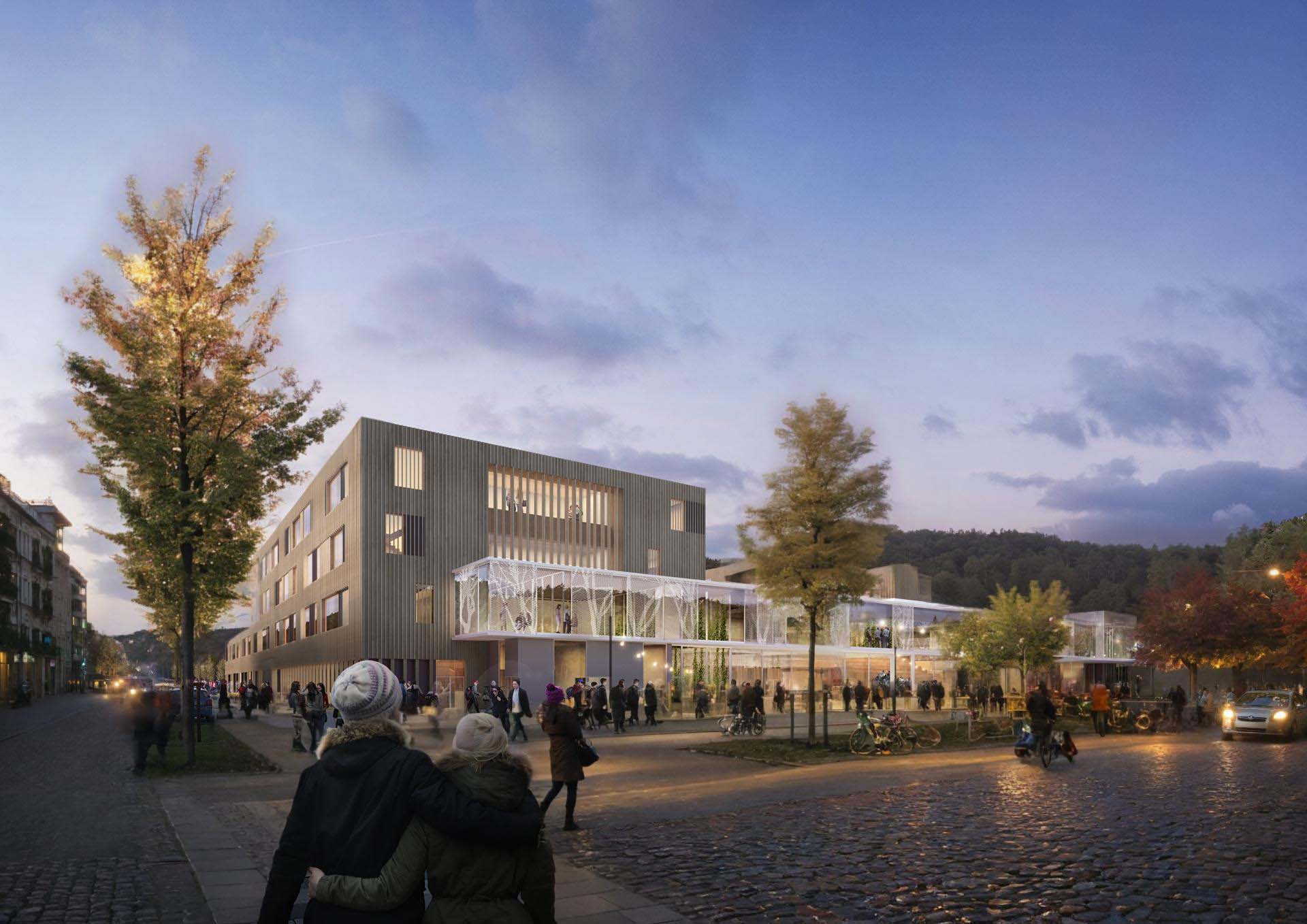 <strong>Tangvall VGS</strong> Evening exterior of the Upper Secondary School in Tangvall Kristiansand Norway designed by L2 Arkitekter developed by Vest-Agder Fylkeskommune and Søgne Municipality featuring illuminated buildings with people walking and cycling in the public space