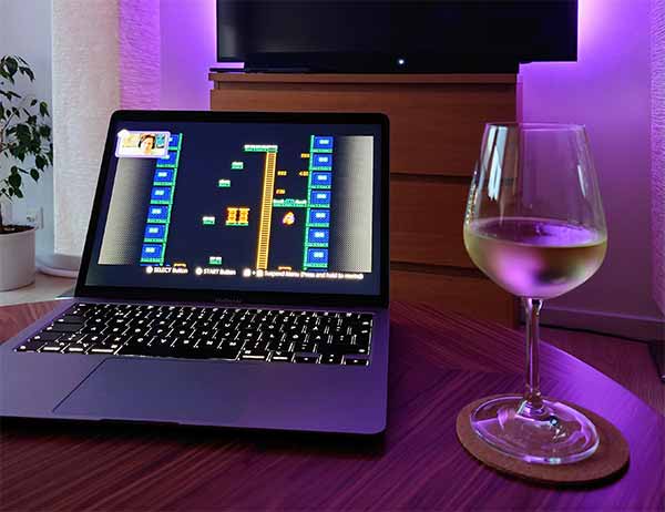 Vitt vin och laptop på ett bord.