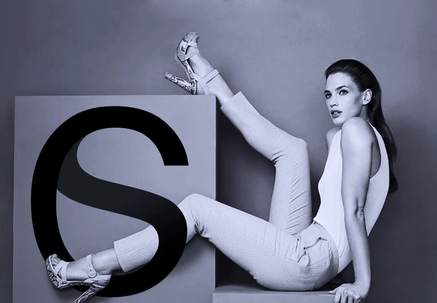 The fashion-forward model poses against a minimalist background with a bold ‘S’ graphic – branding visual by Carlos Simpson Design Studio highlighting elegance, modern typography, and identity-driven design.
