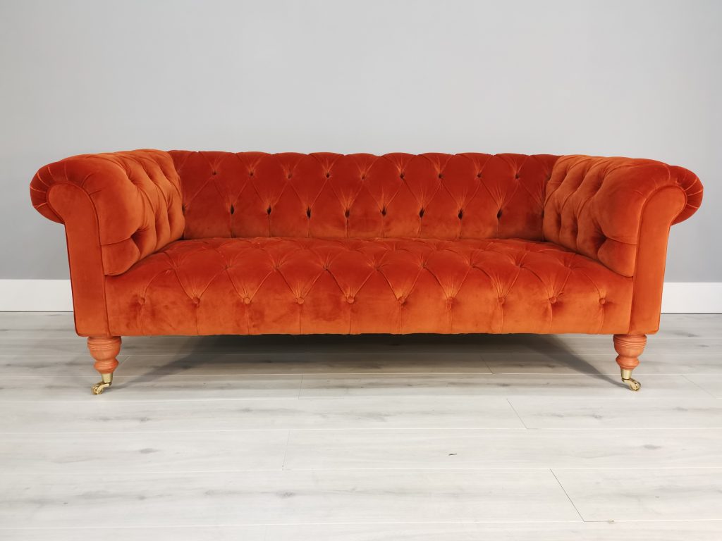 an orange small deep buttoned Chesterfield style sofa