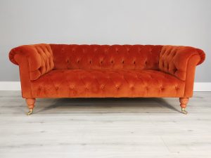 an orange small deep buttoned Chesterfield style sofa