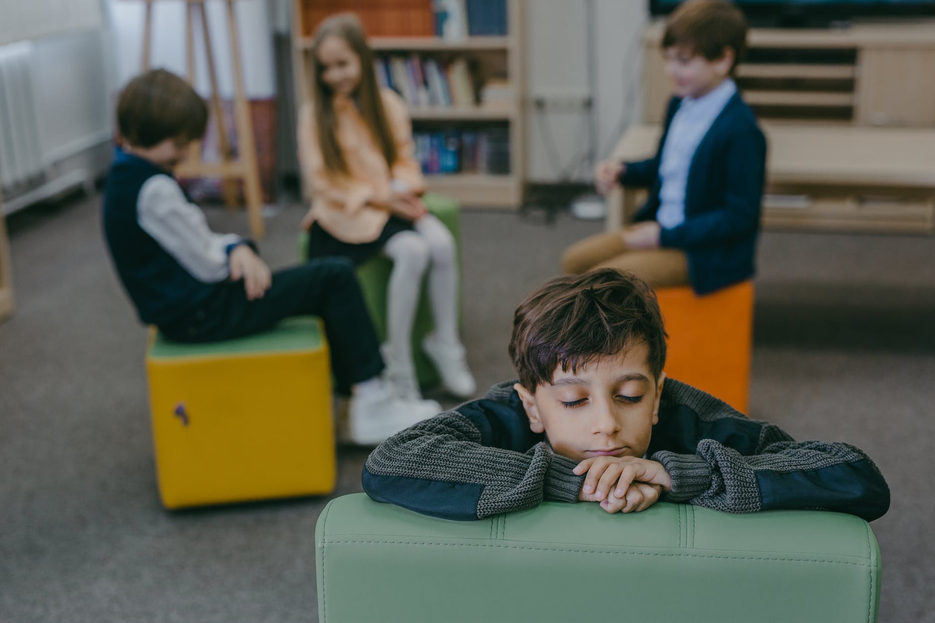 a boy leaning on a chair