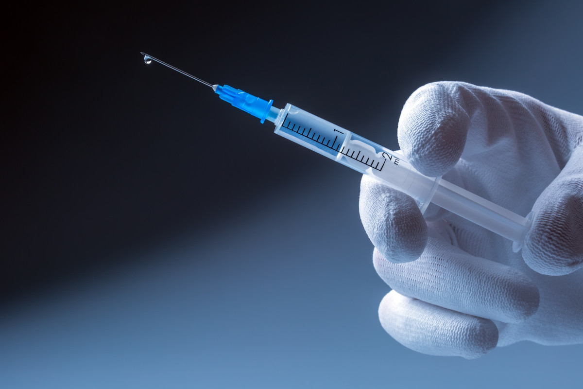 Medical syringe with needle in hand doctor.