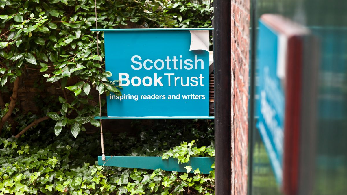 Scottish Book Trust blue sign, surrounded by a lush hedge