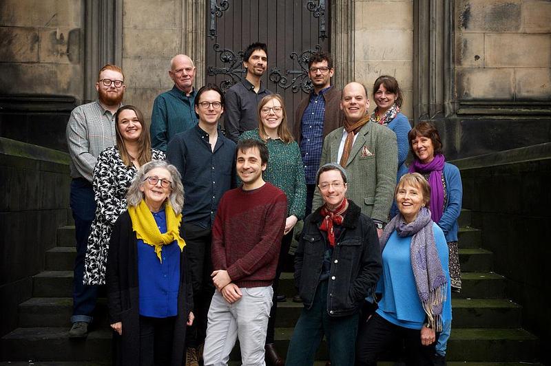 Photo of the current award winners, standing on steps. There are 13 people smiling at the camera.