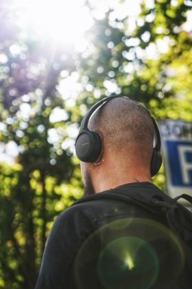 man in black jacket wearing headphones listening to podcast