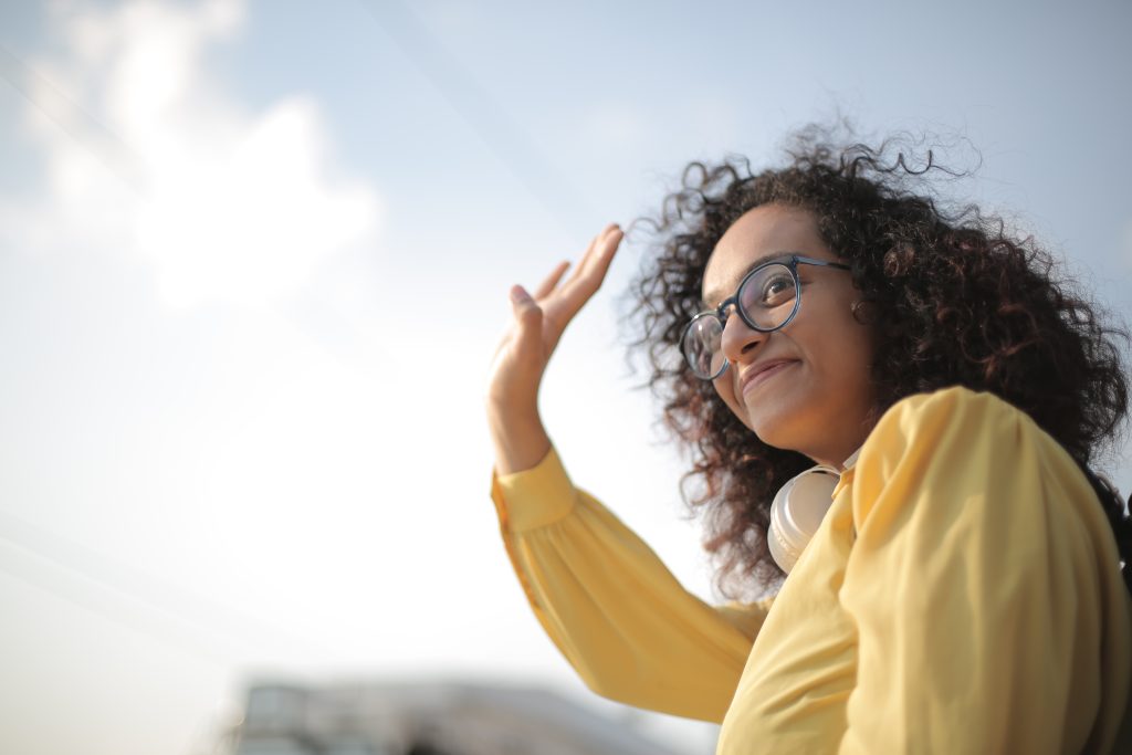 Woman in yellow top waving