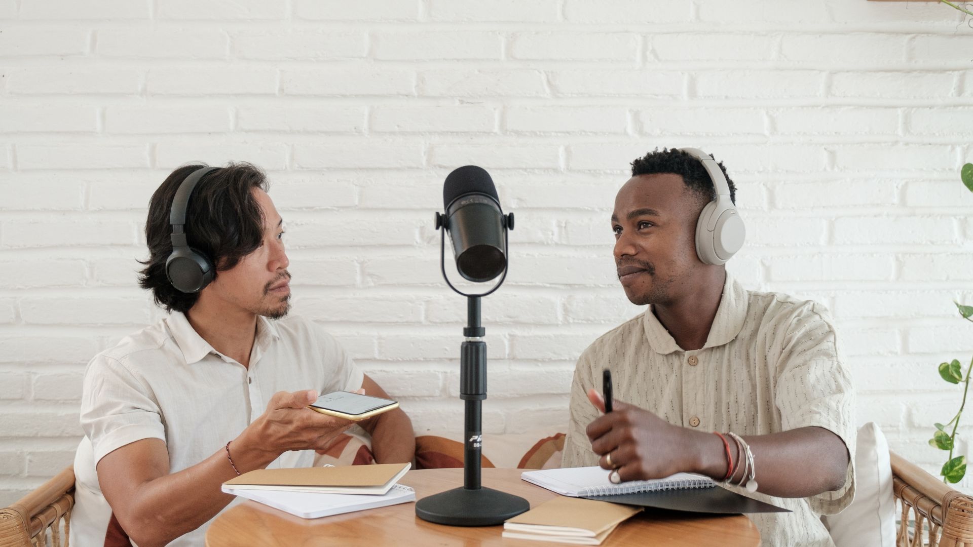 two podcasters with headphones and microphone