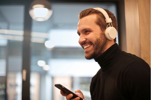 man listening to phone with headphones