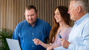Clever Choice medarbejdere diskuterer IT Service Management ved en computer