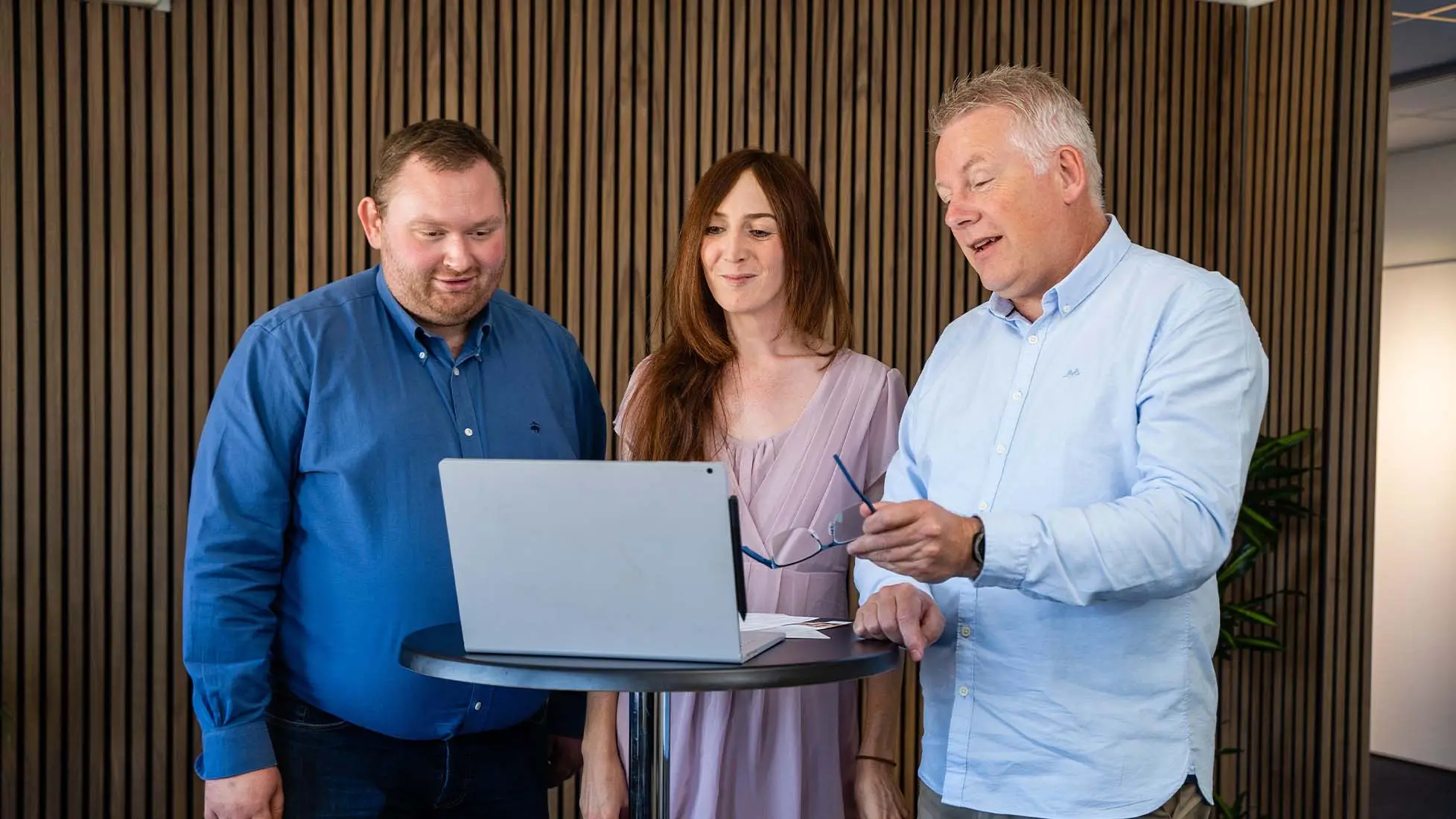 Clever Choice employees discuss IT Service Management at a computer