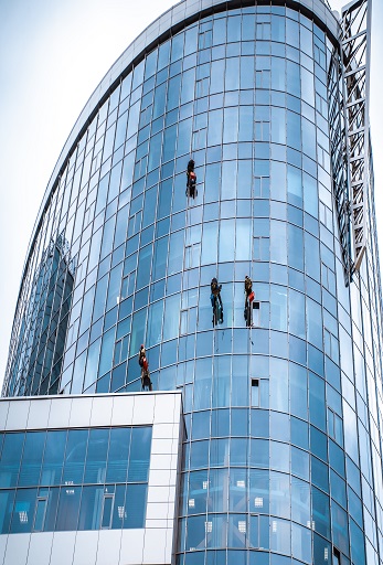 Several workers washing windows in the office building